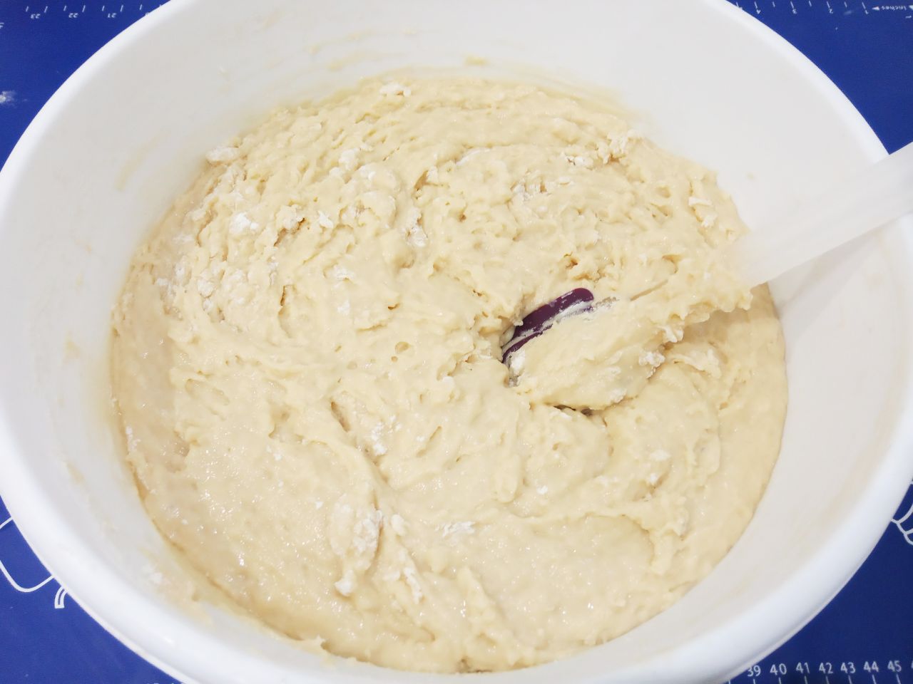 Домашние пасхальные куличи воздушные, мягкие и вкусные: Добавляем часть муки, размешиваем лопаткой.