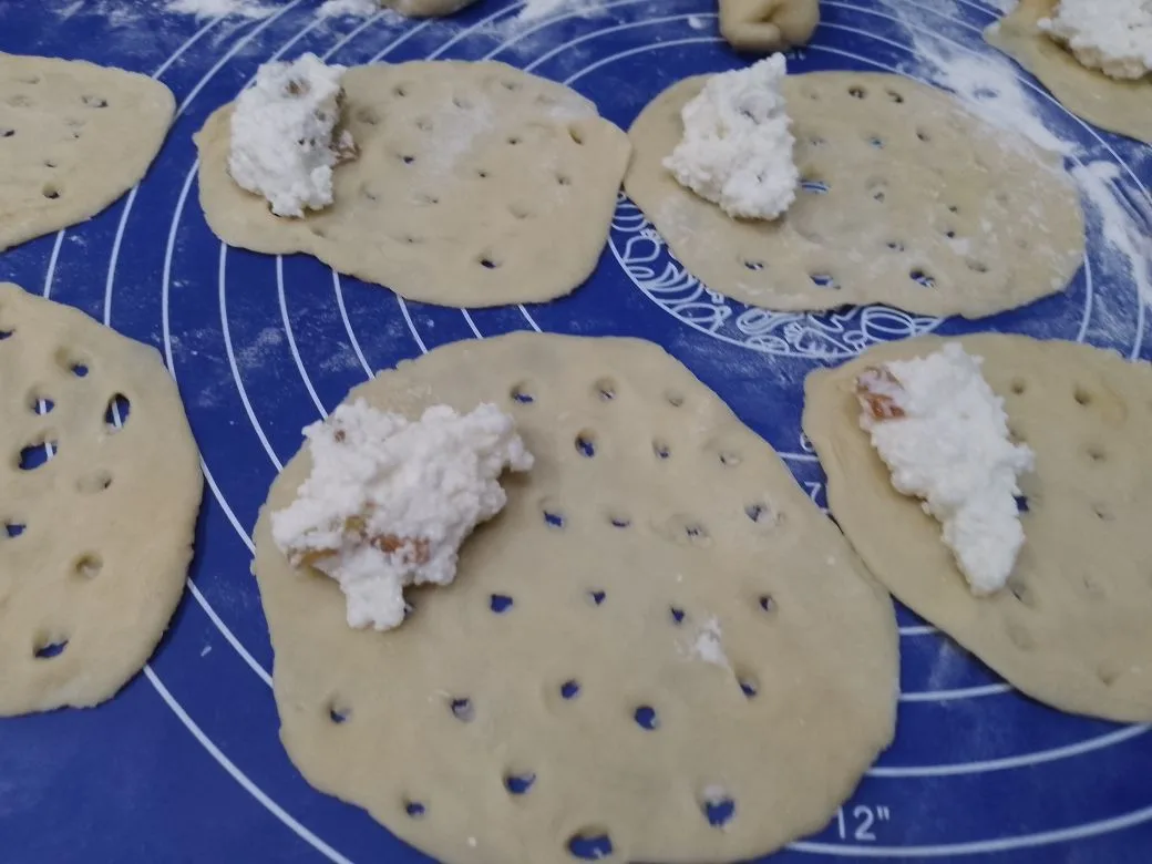 Песочное и рассыпчатое печенье, с начинкой из творога и изюма: На край где нет отверстий кладем творожную начинку примерно столовую ложку без горки.