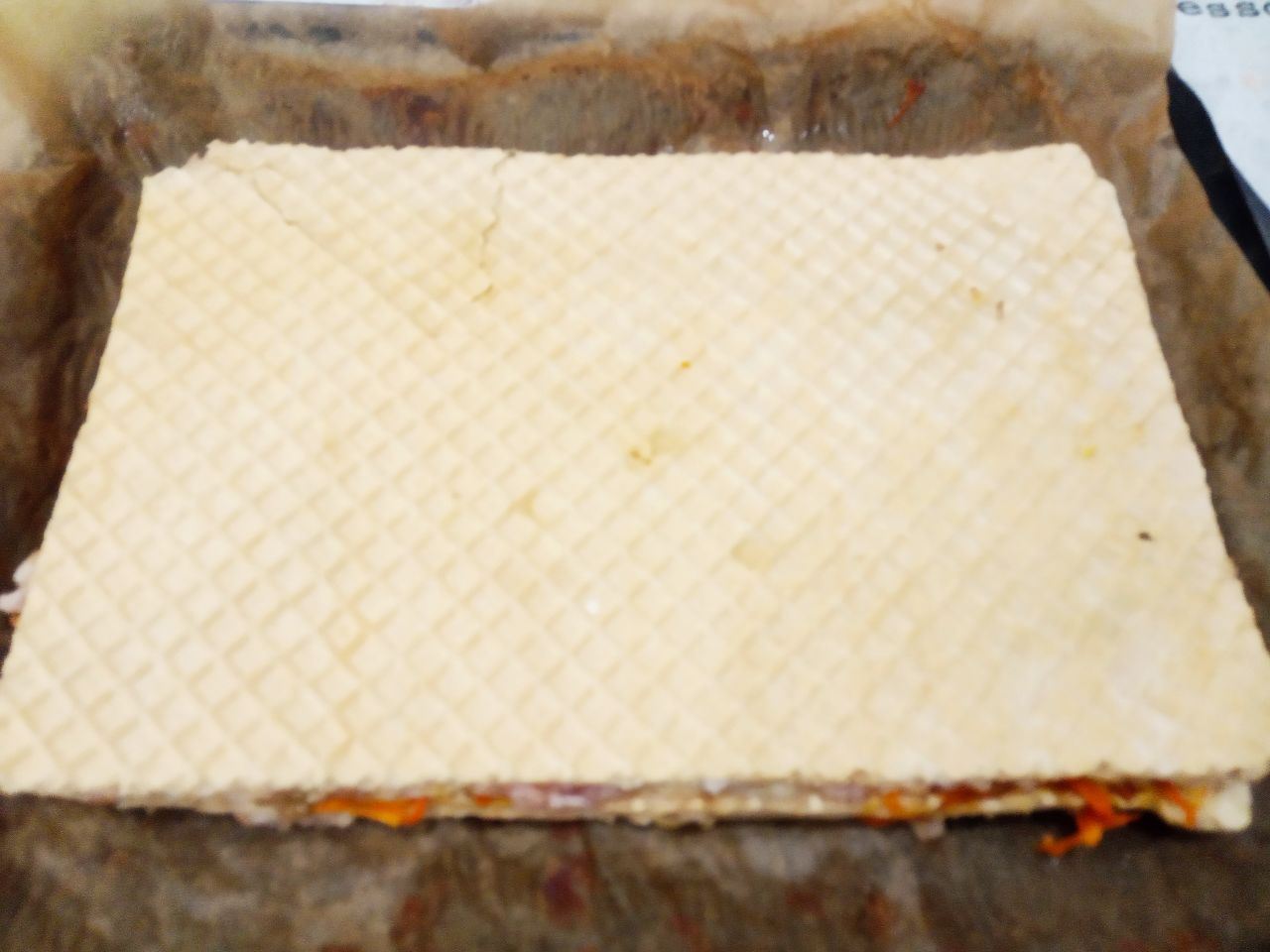 Торт вафельный с начинкой из фарша, моркови и грибов: Противень застилаем пергаментом и укладываем вафельный торт.
