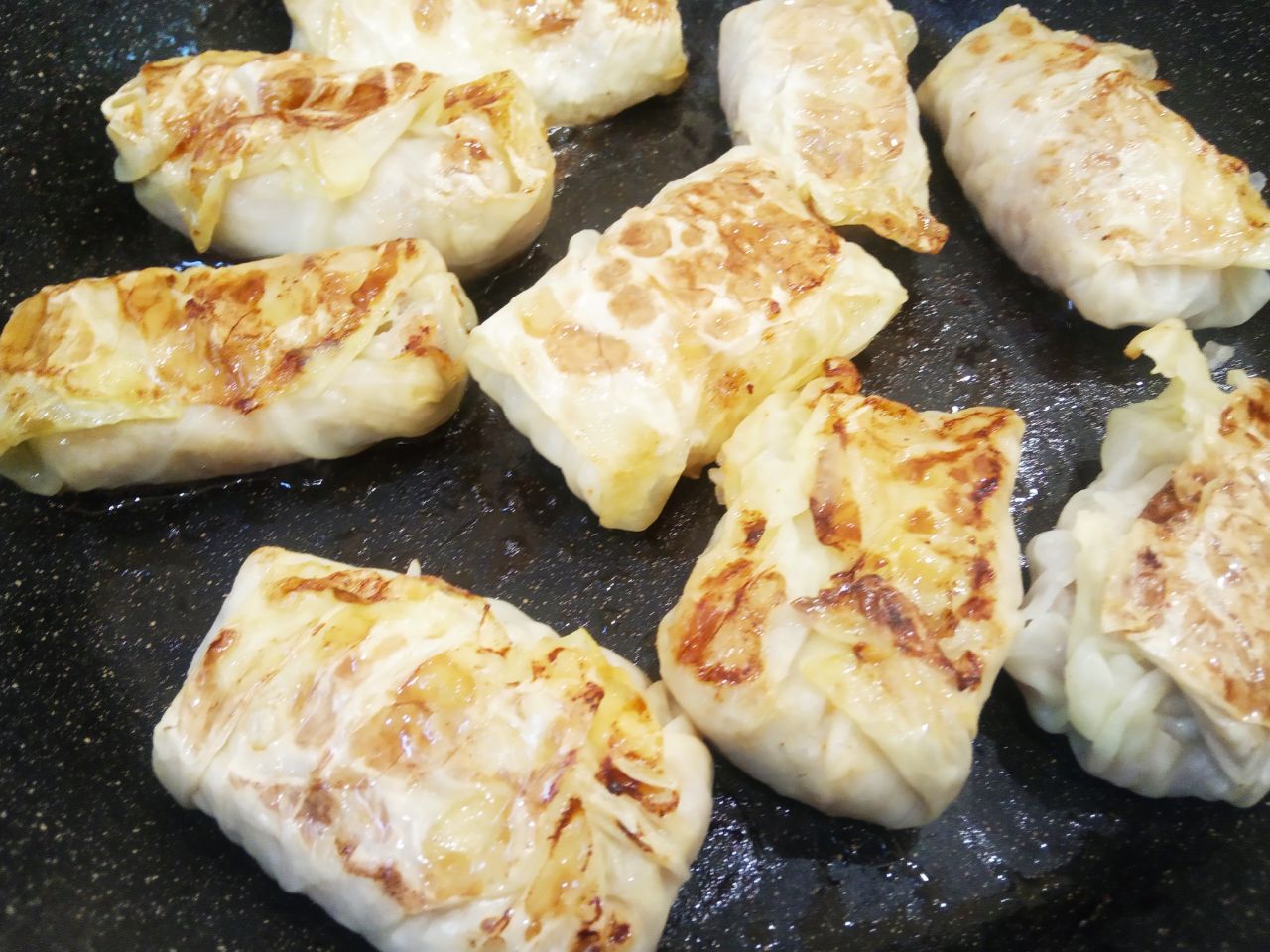 Домашние обжаренные голубцы с сырым рисом, вкусно и сытно: Разогреваем сковороду с растительным маслом и обжариваем голубцы с двух сторон.