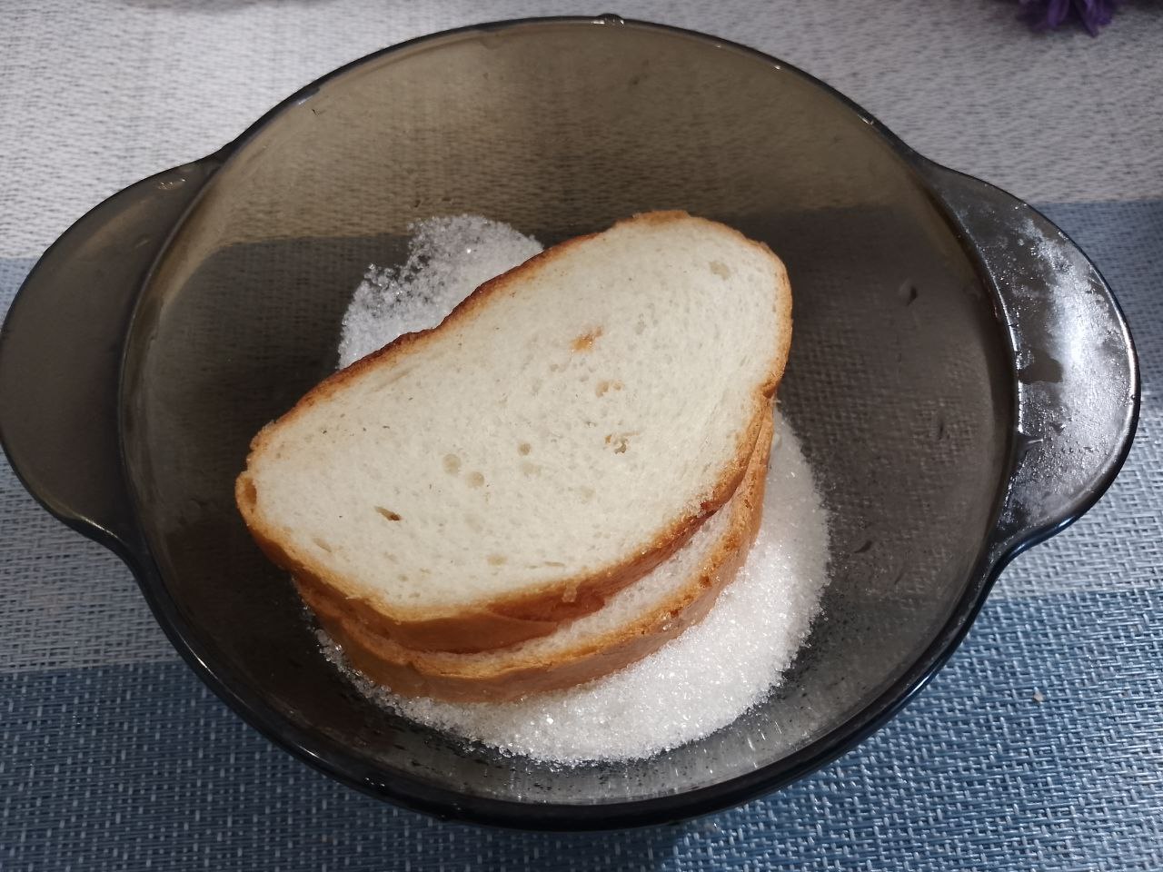 Десерт к чаю из батона, джема, сливочного масла и кунжута: В тарелку насыпаем сахар и окунаем стороной со сливочным маслом.