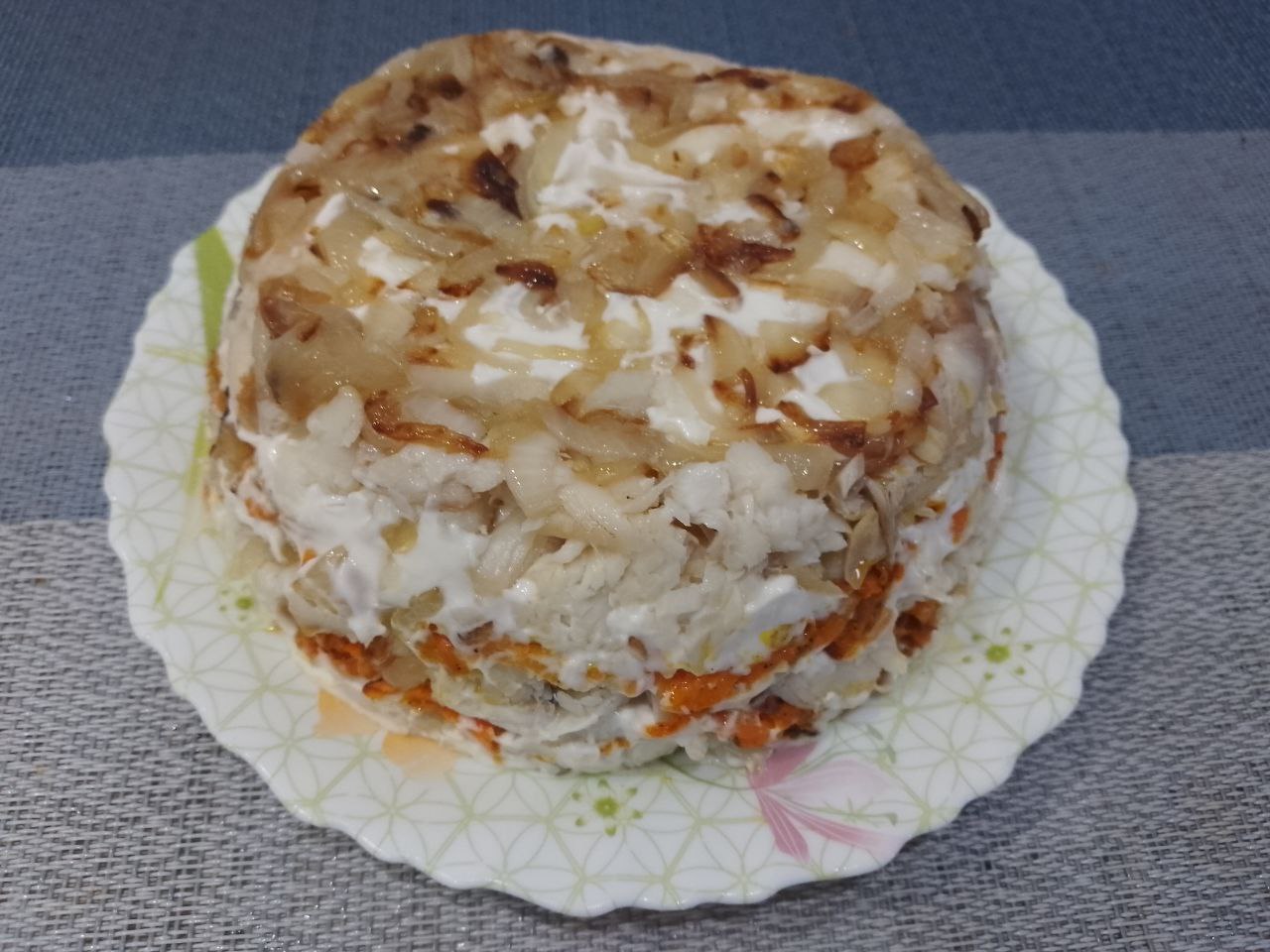 Салат из рыбы, моркови и лука: Тарелкой накрываем чашу и аккуратно переворачиваем салат на тарелку, снимаем пленку.